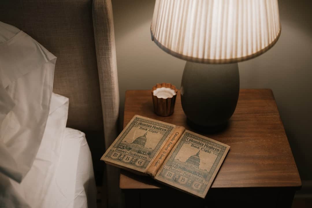 Person liest Buch bei gedämmtem Licht – entspannende Abendroutine für besseren Schlaf