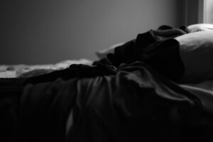 Person beim Sonnenaufgang am Fenster mit Tasse, Tageslicht im Schlafzimmer