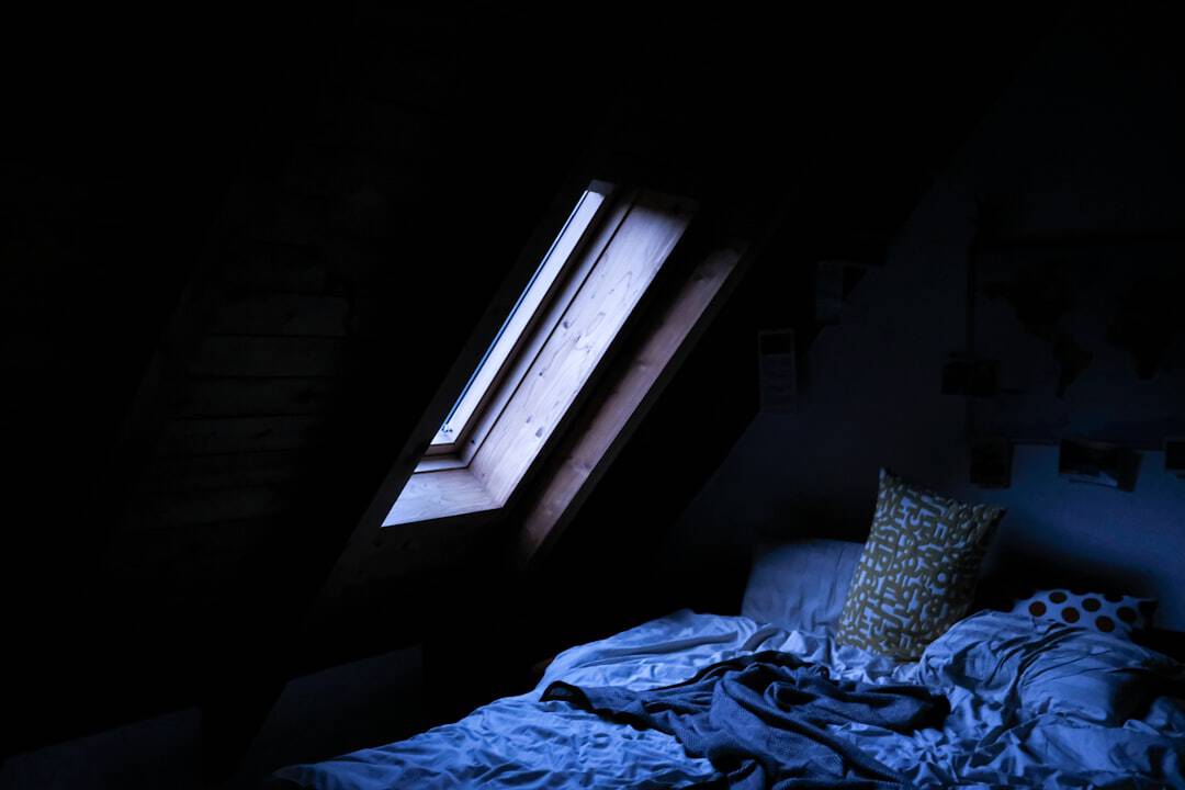 Kühles Schlafzimmer mit Thermometer auf dem Nachttisch — optimale Schlaftemperatur 18 Grad